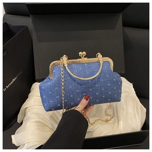 Borsa a conchiglia in denim blu con telaio dorato, catena e texture pompon 3D