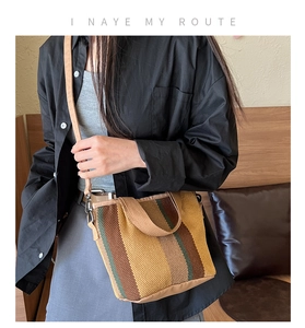 Detail of multi-color striped canvas tote bag with adjustable shoulder strap and metal buckle