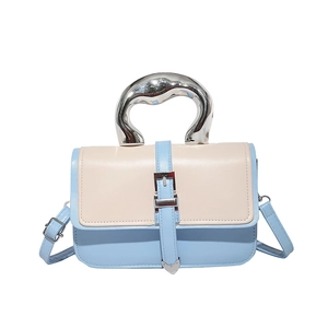 Two-tone blue and cream shoulder bag with sculptural silver metal handle and buckle strap