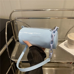 Elegante borsa a cilindro azzurra in pelle lucida con tracolla e catena decorativa