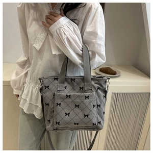 Détail du sac fourre-tout en velours côtelé gris avec motif de nœuds et poche