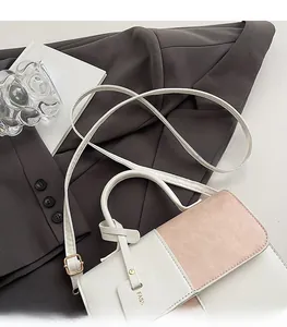 Detail of adjustable shoulder strap with gold buckle on color-block flap crossbody bag
