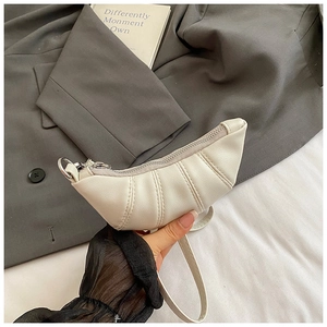 Detailaufnahme der weißen Croissant-Tasche mit Lychee-Leder und silbernem Reißverschluss