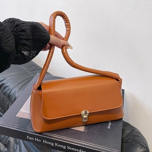 Brown leather underarm bag with pleated circular handle and gold buckle closure