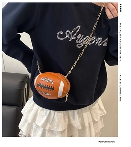 Detail of rugby-shaped crossbody bag with white stripes and golden chain strap
