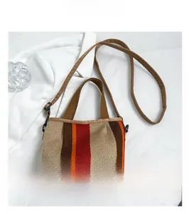 Detail of multi-color striped knit tote bag showing texture and reinforced leather base