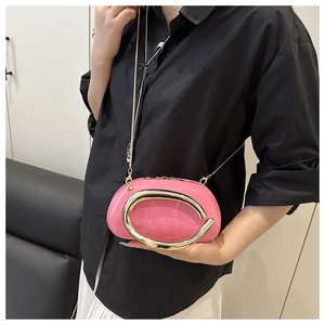 Pochette en cuir verni rose avec une poignée dorée en forme de C et une bandoulière chaîne