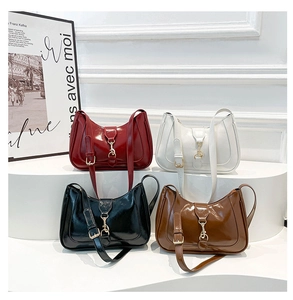 Detailed close-up of glossy retro saddle bags with gold horsebit in four elegant colors