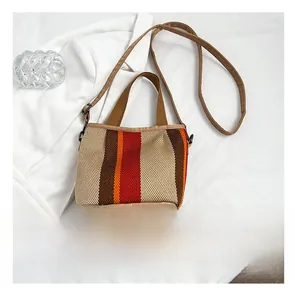Detail of bohemian striped woven tote bag with brown faux leather trim and canvas handles
