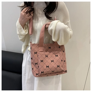 Détail du sac cabas en velours côtelé rose avec motifs nœuds et larges poignées