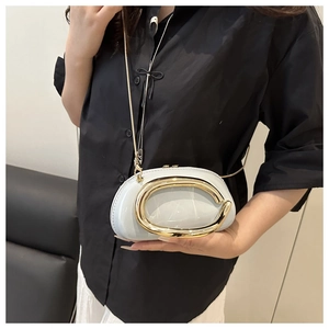 Détail du sac coquille bleu clair avec boucle anneau en C doré et bandoulière chaîne