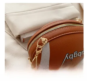 Detailed close-up of golden metal hooks and textured leather on a rugby-shaped bag