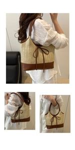 Detail view of woven straw tote bag with brown faux leather trim and ribbon accent