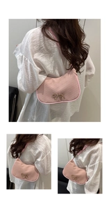 Detail of pink corduroy shoulder bag with golden bow and crescent shape texture