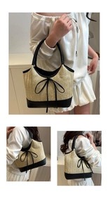 Close-up detail of woven straw tote bag with black leather trim and decorative bow accent