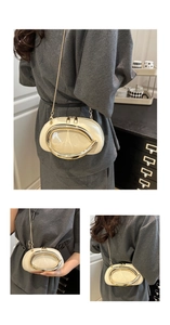 Detailed view of off-white leather round bag with oval gold metal frame and chain strap
