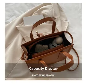 Brown faux leather tote bag with multiple compartments showing large interior capacity