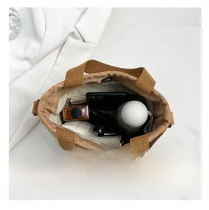 Intérieur spacieux d'un grand sac en toile marron montrant le rangement des accessoires