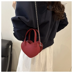 Mannequin portant un mini sac à main rouge en forme de cœur avec bandoulière en chaîne