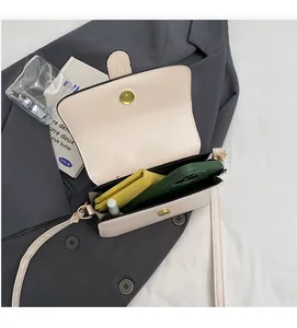 Top view of cream crossbody bag interior showing spacious room for wallet and phone