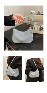 Macro detail of French bow buckle on textured light blue woven shoulder bag