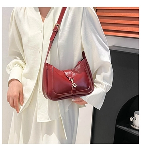 Detailed view of dark red leather hobo bag with golden piston buckle and adjustable strap