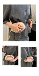 Detail of light pink round handbag featuring shiny patent leather and a gold oval handle