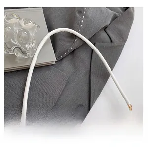 Detail of the soft cylindrical faux leather handle with premium gold metal hardware