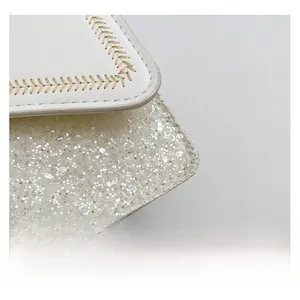 Macro shot of white leather and silver sequins with decorative wheat stitch detail