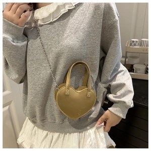 Mini sac coeur doré champagne avec texture en cuir et détail de fine chaîne en métal