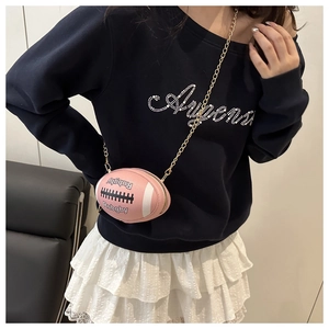 Close-up of pink rugby-shaped mini bag with chain strap worn by a model