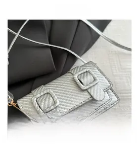 Detailed view of silver mini crossbody bag with carbon fiber texture and square buckles