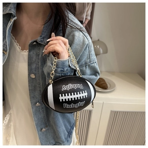 Detailed macro view of the black rugby-shaped handbag featuring gold chain and text