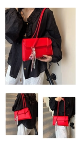 Detail of red leather shoulder bag with decorative woven charm and lifestyle model view