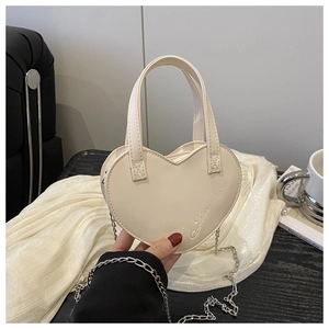 Détail du sac à main cœur crème avec bandoulière chaîne argentée et poignée