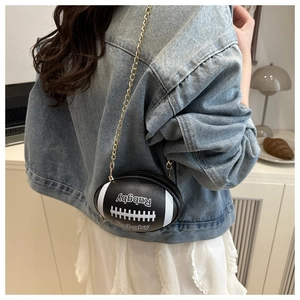 Detail of rugby-shaped crossbody bag featuring black lychee texture and gold chain strap