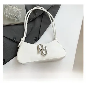 Détail du sac baguette en similicuir blanc avec boucle argentée et smartphone pour comparer la taille