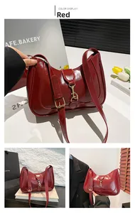 Detailed view of red glossy leather hobo bag with adjustable strap and golden metal buckle