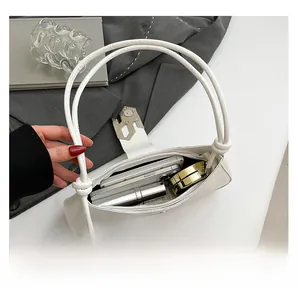 Gros plan d'un sac porté épaule blanc montrant sa capacité pour téléphone et maquillage