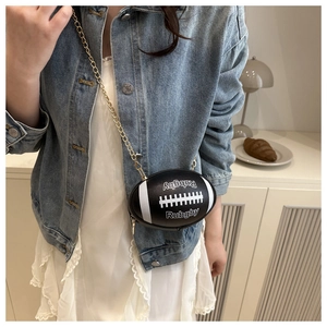 Detail of rugby-shaped black crossbody bag with white stripes and gold chain strap