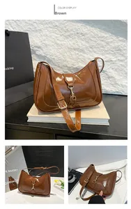 Detail of glossy brown leather handbag featuring golden metal buckle and sleek finish