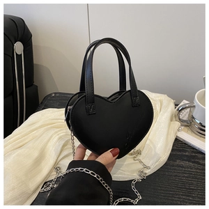 Détail du sac à main noir en forme de cœur avec gravure subtile et chaîne argentée