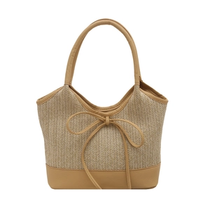 Straw woven tote bag with bow detail and leather trim for summer beach vacation style