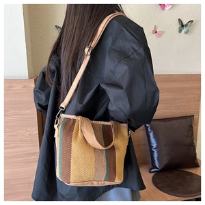 Detail showing the vintage plaid woven texture and adjustable strap of the shoulder bag