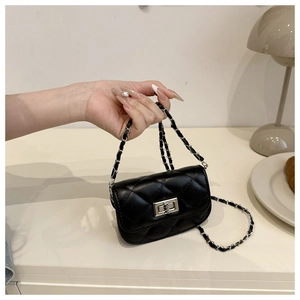 Détail macro du mini sac matelassé avec chaîne argentée et fermoir rotatif en métal