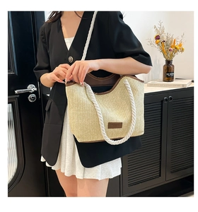 Mannequin portant un grand sac de plage en paille tressée avec des poignées en corde blanche
