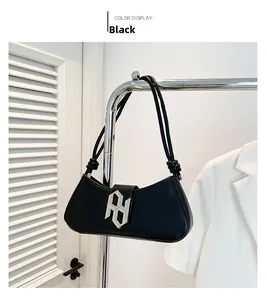 Détail du sac bandoulière en cuir PU noir avec boucle argentée et fines bandoulières