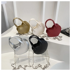 Détail de mini sacs en forme de cœur en diverses couleurs avec bandoulière chaîne