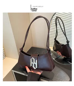 Détail du sac baguette en cuir PU marron foncé avec boucle géométrique argentée