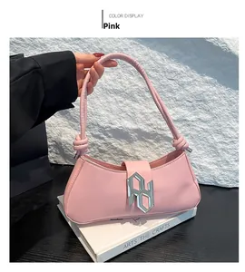 Détail du sac baguette en similicuir rose avec poignée nouée et boucle argentée